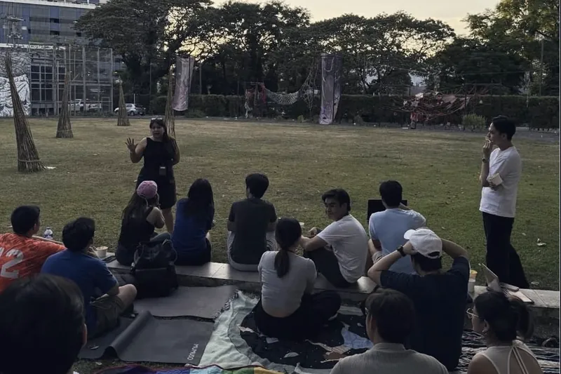 Members sitting in a circle on the grass