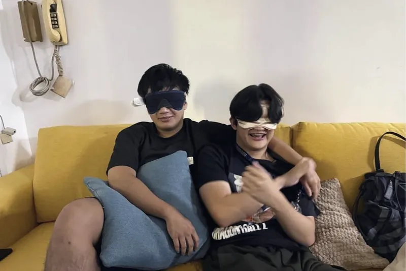 Two members in blindfolds on a couch during an icebreaker